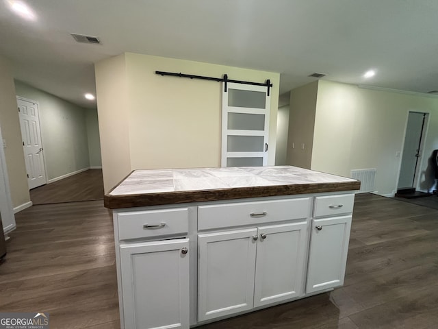 411 Woodland Dr, Hinesville, GA 31313 - kitchen with a barn door, visible vents, and white cabinetry