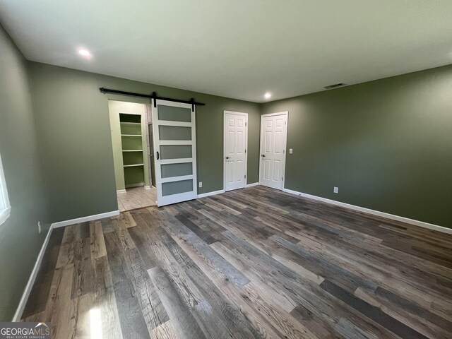 411 Woodland Dr, Hinesville, GA 31313 - empty room featuring visible vents, baseboards, a barn door, recessed lighting, and wood finished floors