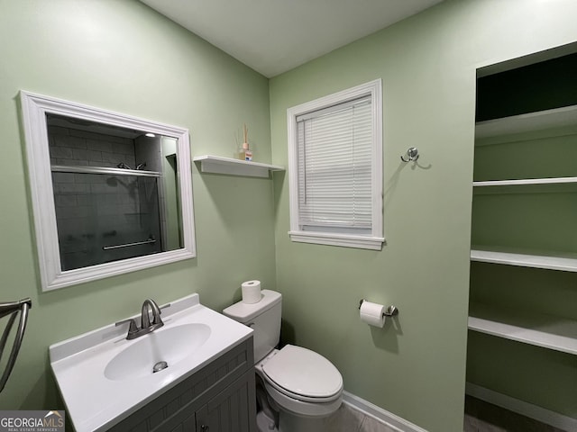411 Woodland Dr, Hinesville, GA 31313 - bathroom with tiled shower, vanity, baseboards, and toilet