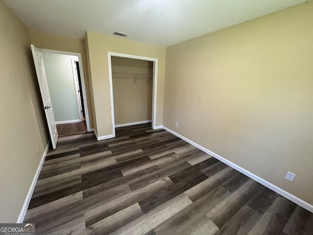 411 Woodland Dr, Hinesville, GA 31313 - unfurnished bedroom featuring visible vents, baseboards, a closet, and dark wood-style floors