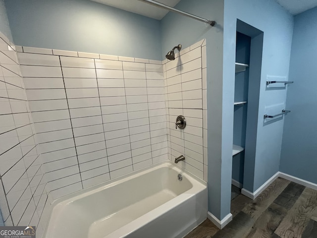 411 Woodland Dr, Hinesville, GA 31313 - bathroom featuring wood finished floors, baseboards, and  shower combination