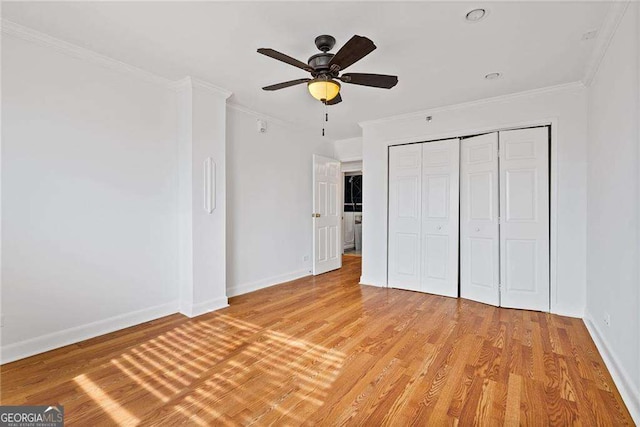 unfurnished bedroom with light wood-style flooring, crown molding, and baseboards