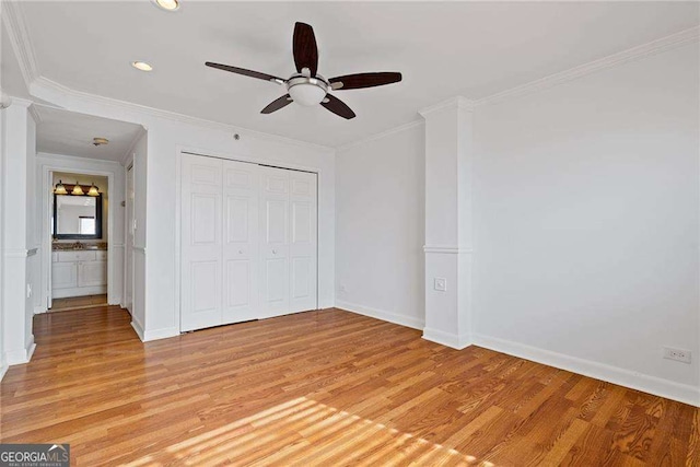 unfurnished bedroom featuring a closet, light wood-style flooring, baseboards, ornamental molding, and ceiling fan