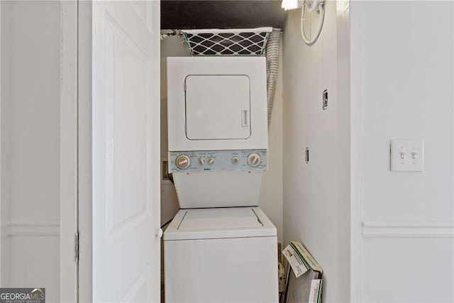 laundry area with stacked washer / drying machine and laundry area