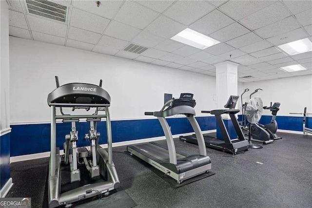 workout area with a drop ceiling, baseboards, and visible vents