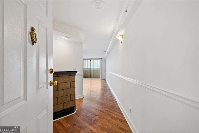 hallway featuring ornamental molding, baseboards, and wood finished floors