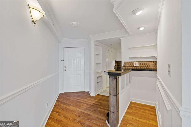 corridor featuring light wood-style floors and ornamental molding