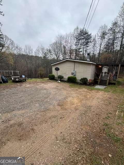 view of yard featuring driveway and a deck