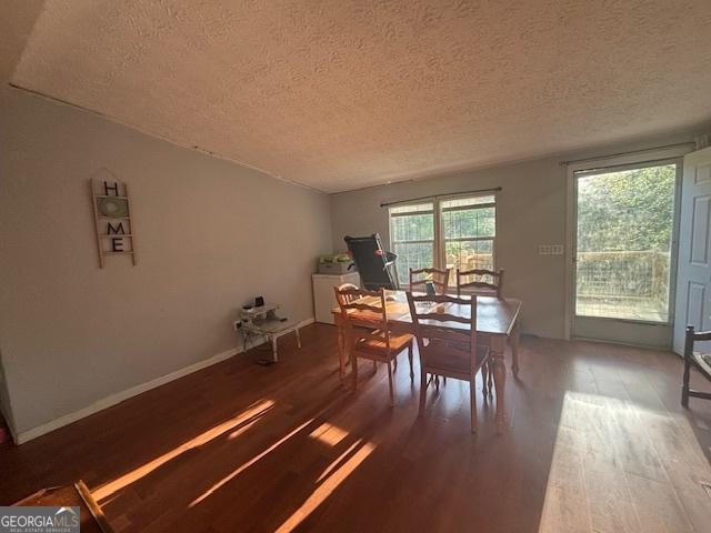 dining room with wood finished floors and a textured ceiling