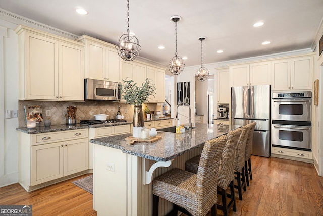 3227 Aviary Ct NW, Acworth, GA 30101 - kitchen with stainless steel appliances, cream cabinetry, a sink, tasteful backsplash, and light wood-style flooring