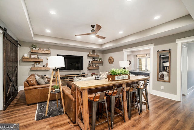 3227 Aviary Ct NW, Acworth, GA 30101 - living room with a barn door, a tray ceiling, baseboards, wood finished floors, and ceiling fan