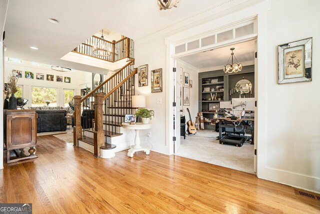 3227 Aviary Ct NW, Acworth, GA 30101 - entrance foyer with a chandelier, wood finished floors, stairway, baseboards, and crown molding