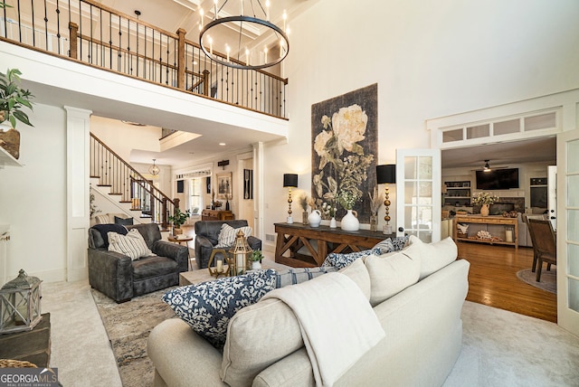 3227 Aviary Ct NW, Acworth, GA 30101 - living room featuring a high ceiling, stairs, a ceiling fan, baseboards, and wood finished floors