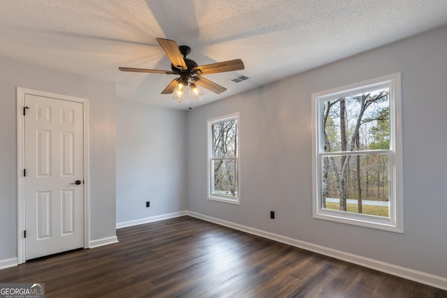 unfurnished bedroom with dark wood-style floors, baseboards, a textured ceiling, and visible vents