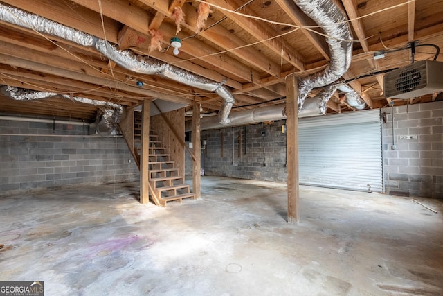 unfinished below grade area featuring stairway and concrete block wall