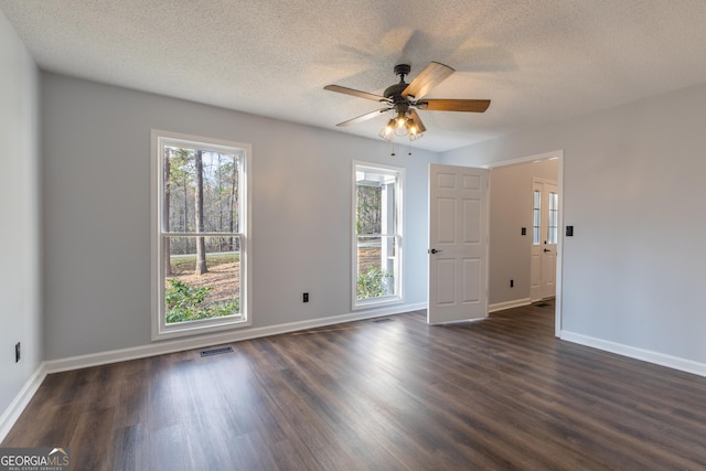 spare room with dark wood finished floors, baseboards, a ceiling fan, and visible vents