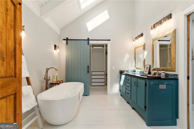 full bath featuring a freestanding tub, beamed ceiling, vanity, a skylight, and high vaulted ceiling