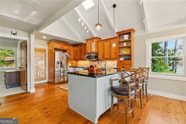 kitchen with stainless steel appliances, beam ceiling, open shelves, and dark countertops