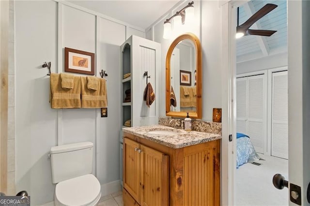 bathroom featuring vanity, tile patterned floors, toilet, beamed ceiling, and ceiling fan