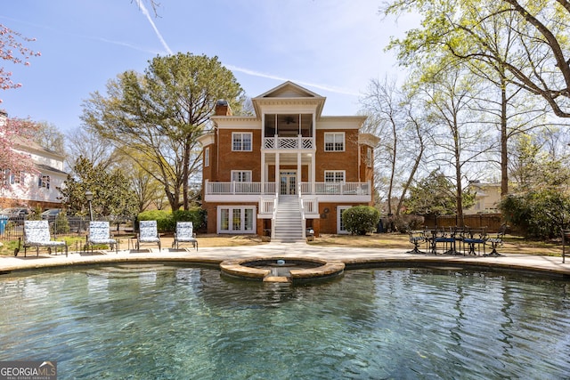 3847 Sweet Bottom Dr, Duluth, GA 30096 - back of house with french doors, a balcony, stairway, a pool with connected hot tub, and a patio
