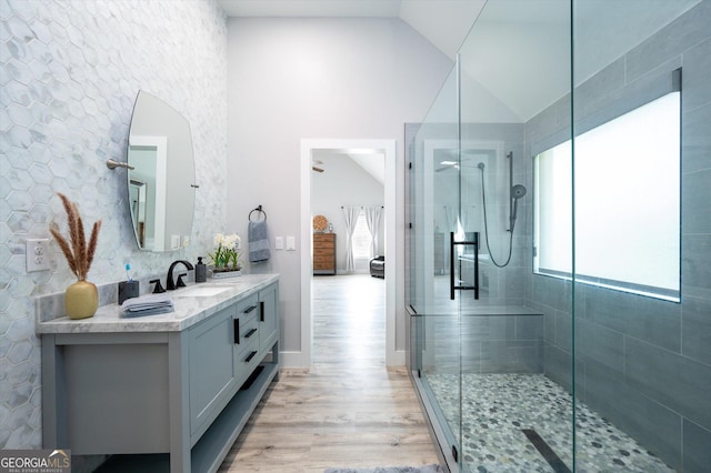 full bathroom with wood finished floors, a ceiling fan, vanity, lofted ceiling, and a stall shower