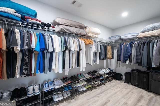 spacious closet featuring wood finished floors and visible vents