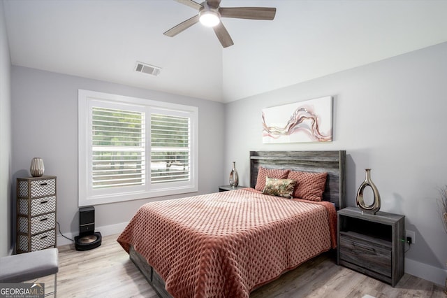 bedroom featuring baseboards, visible vents, wood finished floors, and vaulted ceiling