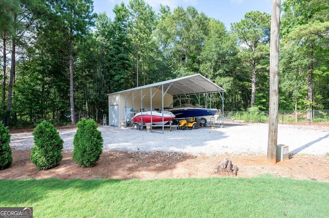 view of car parking with fence, gravel driveway, and a detached carport
