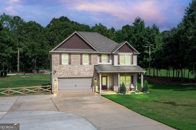 craftsman inspired home featuring driveway, an attached garage, fence, and a front lawn