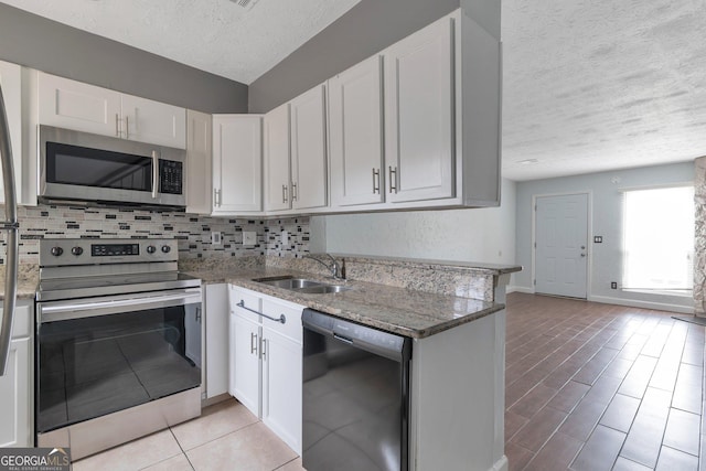 kitchen featuring white cabinetry, a sink, stainless steel appliances, and tasteful backsplash