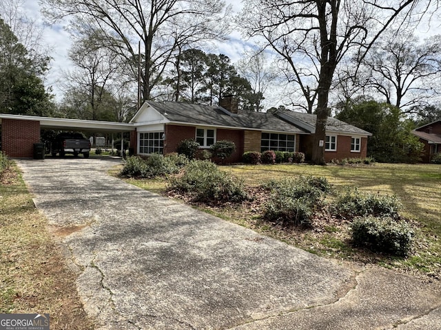 single story home with driveway, a front lawn, brick siding, an attached carport, and a chimney