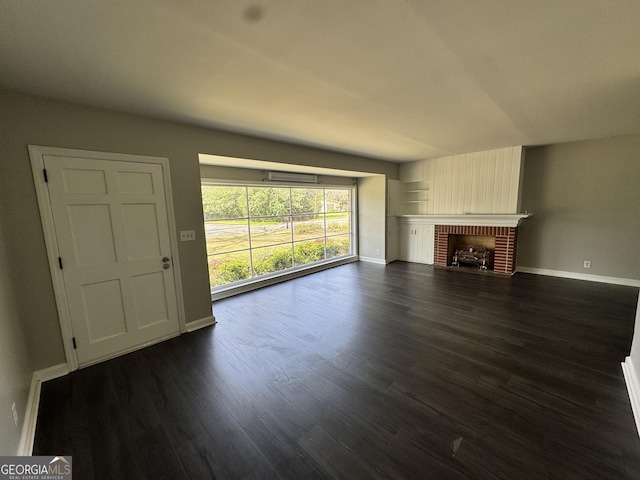 unfurnished living room with dark wood-style floors, baseboards, and a fireplace