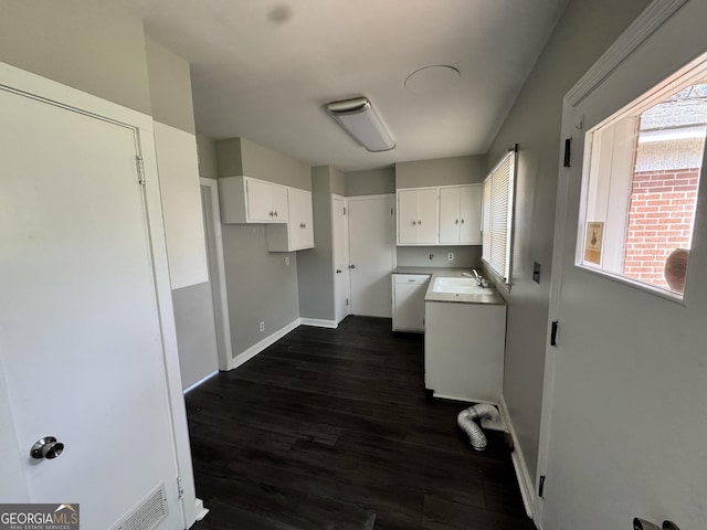 laundry area with cabinet space, a wealth of natural light, separate washer and dryer, and dark wood-style flooring