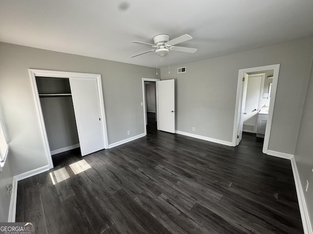 unfurnished bedroom featuring baseboards, dark wood-style floors, visible vents, and a closet