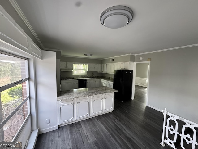 kitchen with crown molding, light countertops, a peninsula, black appliances, and dark wood-type flooring