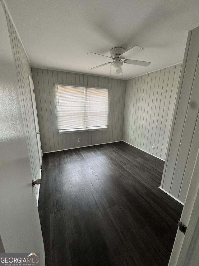 unfurnished room with dark wood-type flooring and ceiling fan