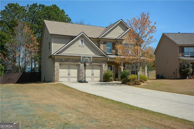 craftsman house with a front yard, concrete driveway, fence, central air condition unit, and brick siding
