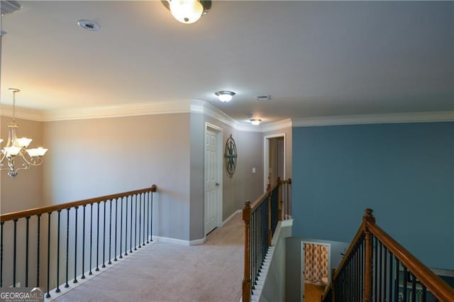 hall featuring baseboards, an upstairs landing, a chandelier, crown molding, and carpet floors