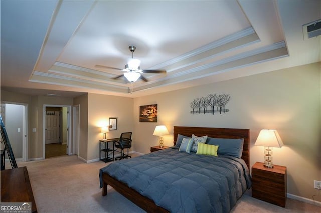 bedroom with visible vents, baseboards, ornamental molding, a tray ceiling, and carpet floors