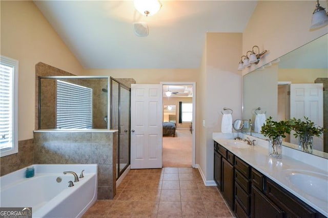 full bath featuring a shower stall, a bath, lofted ceiling, tile patterned floors, and double vanity