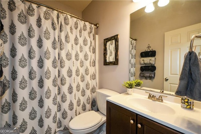 bathroom featuring a shower with shower curtain, vanity, and toilet