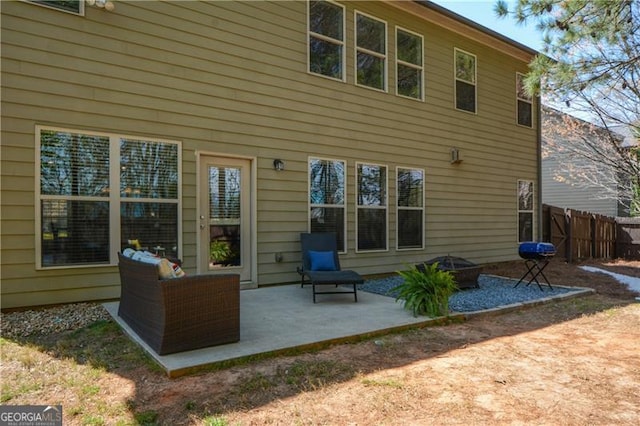 back of house with an outdoor fire pit, fence, and a patio
