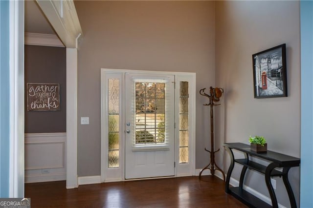 entrance foyer with crown molding, baseboards, and wood finished floors