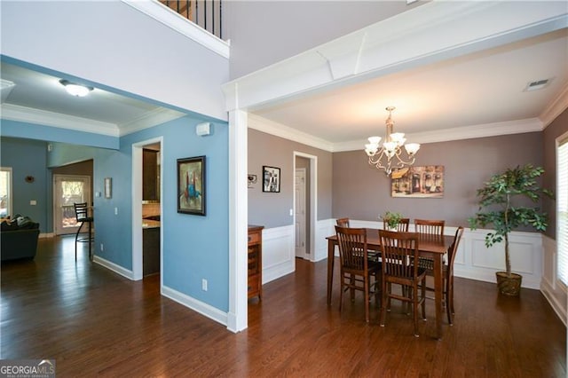 dining space featuring a chandelier, a wealth of natural light, ornamental molding, and wood finished floors