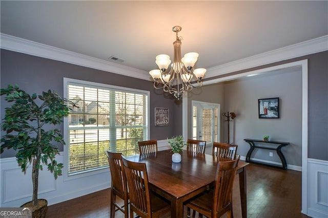 dining room with visible vents, baseboards, a notable chandelier, ornamental molding, and dark wood finished floors