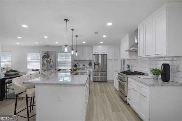 2041 Briarcliff Rd NE, Atlanta, GA 30329 - kitchen with stainless steel appliances, wall chimney exhaust hood, light wood finished floors, white cabinets, and recessed lighting