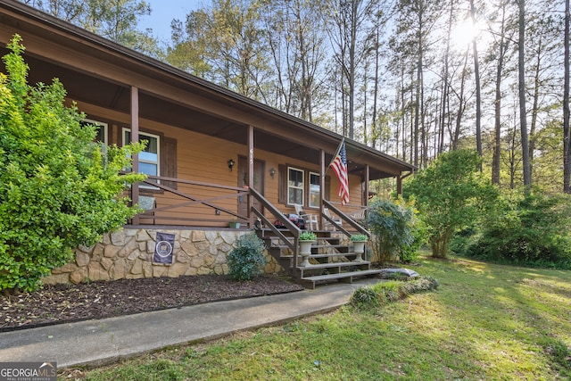 entrance to property with a yard and covered porch