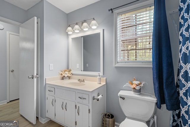 full bathroom featuring wood finished floors, vanity, and toilet