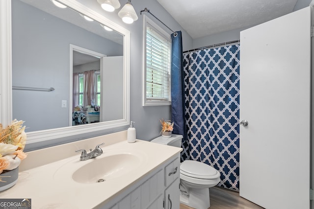 bathroom with wood finished floors, vanity, curtained shower, and toilet