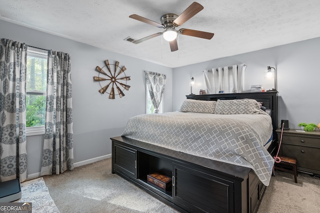 bedroom featuring ceiling fan, light carpet, visible vents, and baseboards
